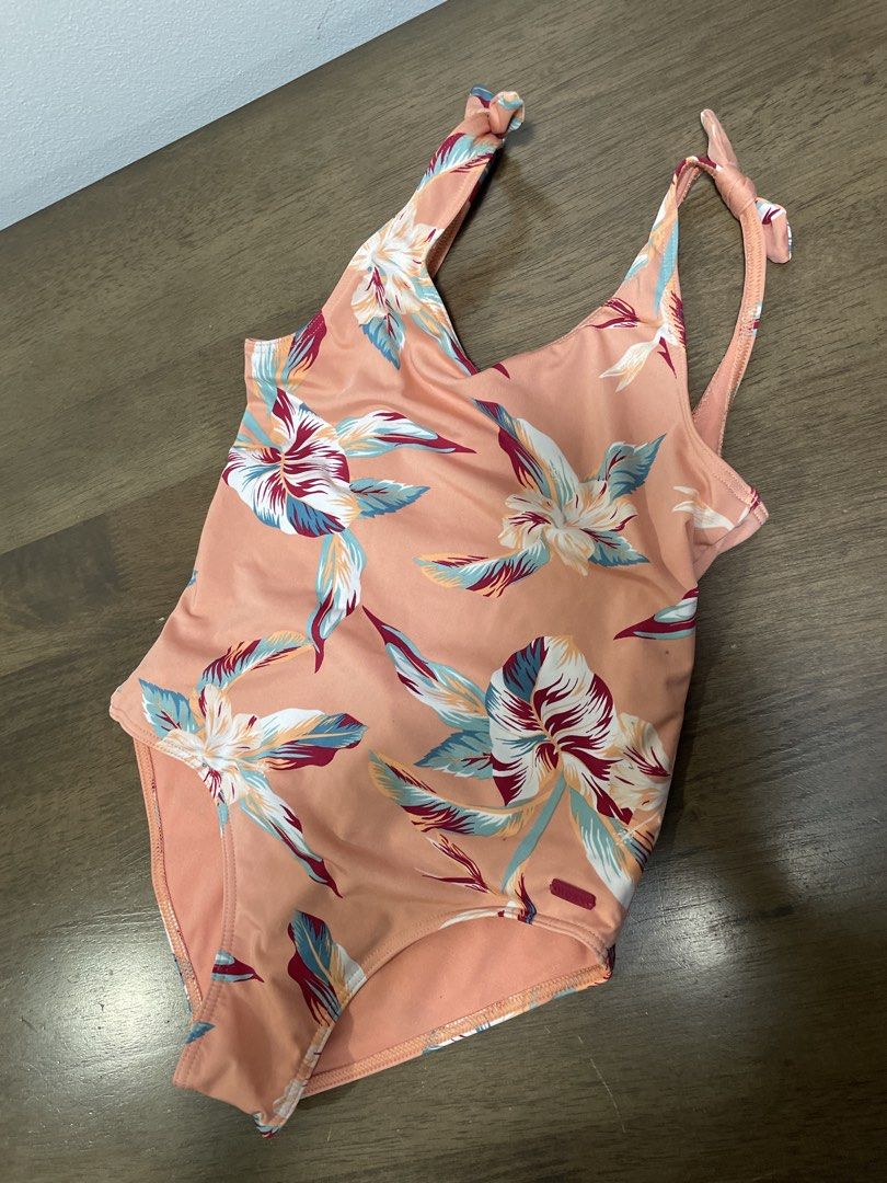 Roxy One-Piece Swimsuit Floral Print (Category: Babies & Kids Fashion) located in Quezon City. Submitted by krystala98 (Listing ID 1444066704, Image 2). Description: - Roxy one-piece swimsuit - Peach tone with tropical floral print (white, blue, maroon accents) - Tie shoulder straps - Low back design - Material: Polyester and elastane blend - Ideal for beach or pool days -Best for 5-8 yo -Buyer to arrange for pick-up and shoulder SF.
