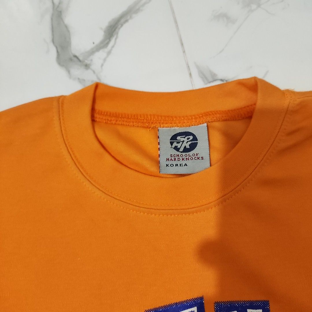 School of Hard Knocks Orange Graphic tshirt (Category: Earphones) located in Maria Aurora. Submitted by pewpewww22 (Listing ID 1443981769, Image 3). Description: dimes-20 by 26 inch deadstock no issue.