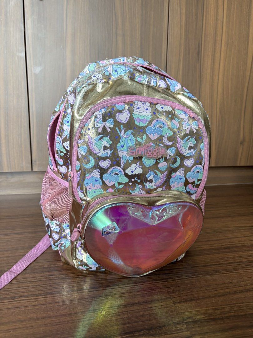 Smiggle Unicorn Cupcake Backpack Gold Pink Heart (Category: Backpacks) located in Makati City. Submitted by homeandbaby (Listing ID 1443929356, Image 1). Description: - Adorable Smiggle backpack with a fun unicorn and cupcake print. - Stylish gold and pink color scheme. - Features a cute, shiny heart pocket on the front. - Interior is clean and includes practical dividers. - Ideal for school, kindergarten, or everyday adventures..