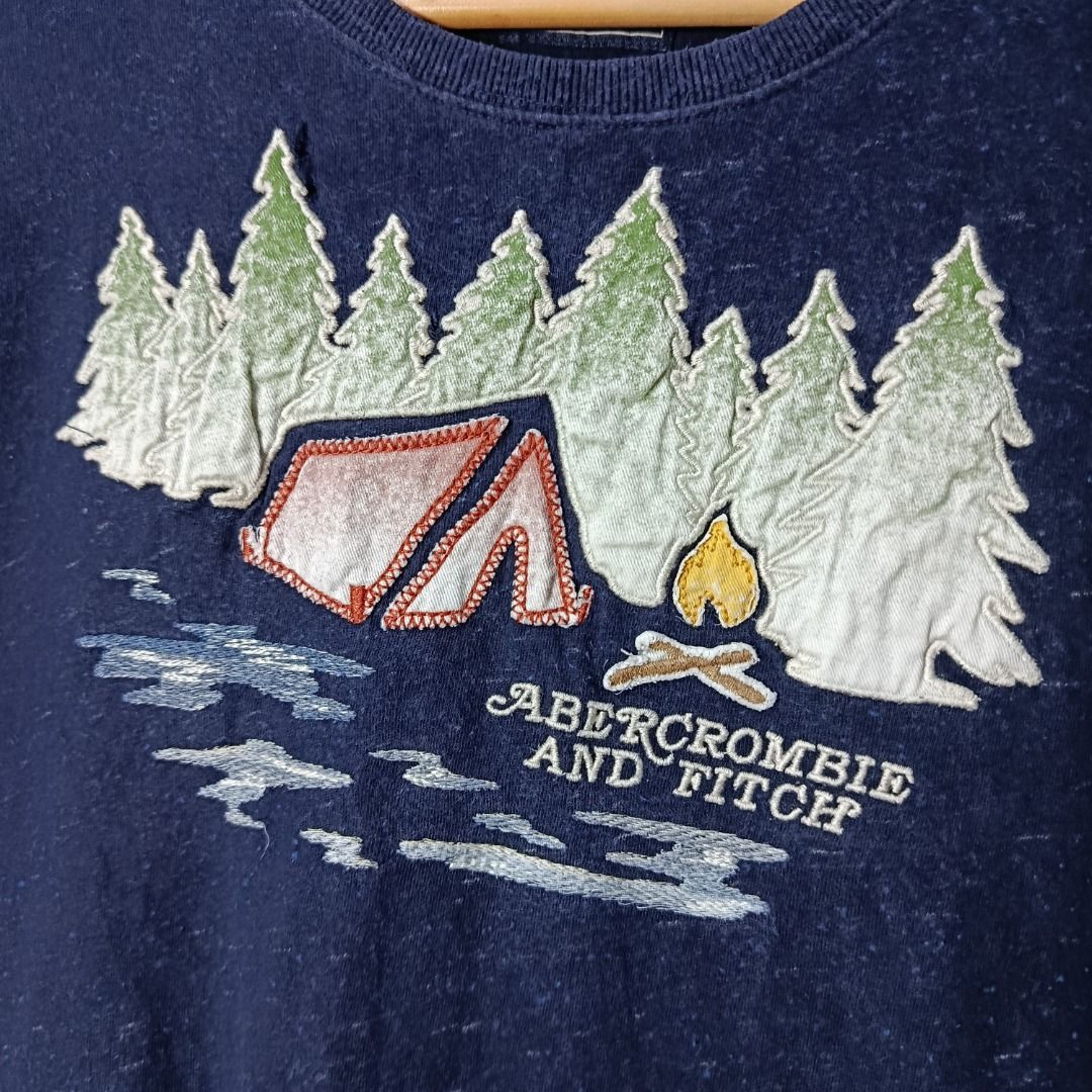Vintage Abercrombie Camp Scene Graphic Tee (Category: Shirts) located in Taytay. Submitted by hoodgrail.vtg (Listing ID 1444055990, Image 3). Description: • Good condition - Lightly used • Multi-layer appliqué and embroidered camping graphic • Size on tag: M — best fits M • Measurements: 18.5 x 28.5 in • Color rate: 9/10 • Issue: None.