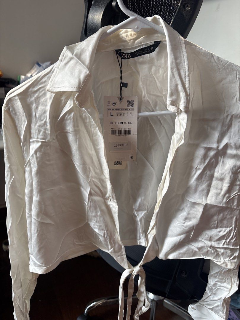 Zara White Cropped Tie Front Shirt Size L (Category: Shirts) located in Manila. Submitted by changli2 (Listing ID 1443993752, Image 3). Description: - Zara white cropped shirt - Long sleeves with tie front detail - Collared neckline - Satin-like material - Brand new with original tags attached - Never worn.