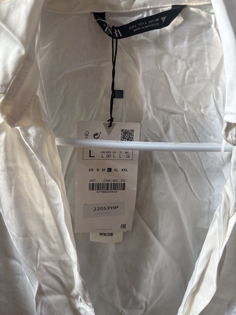 Zara White Cropped Tie Front Shirt Size L (Category: Shirts) located in Manila. Submitted by changli2 (Listing ID 1443993752, Image 2). Description: - Zara white cropped shirt - Long sleeves with tie front detail - Collared neckline - Satin-like material - Brand new with original tags attached - Never worn.