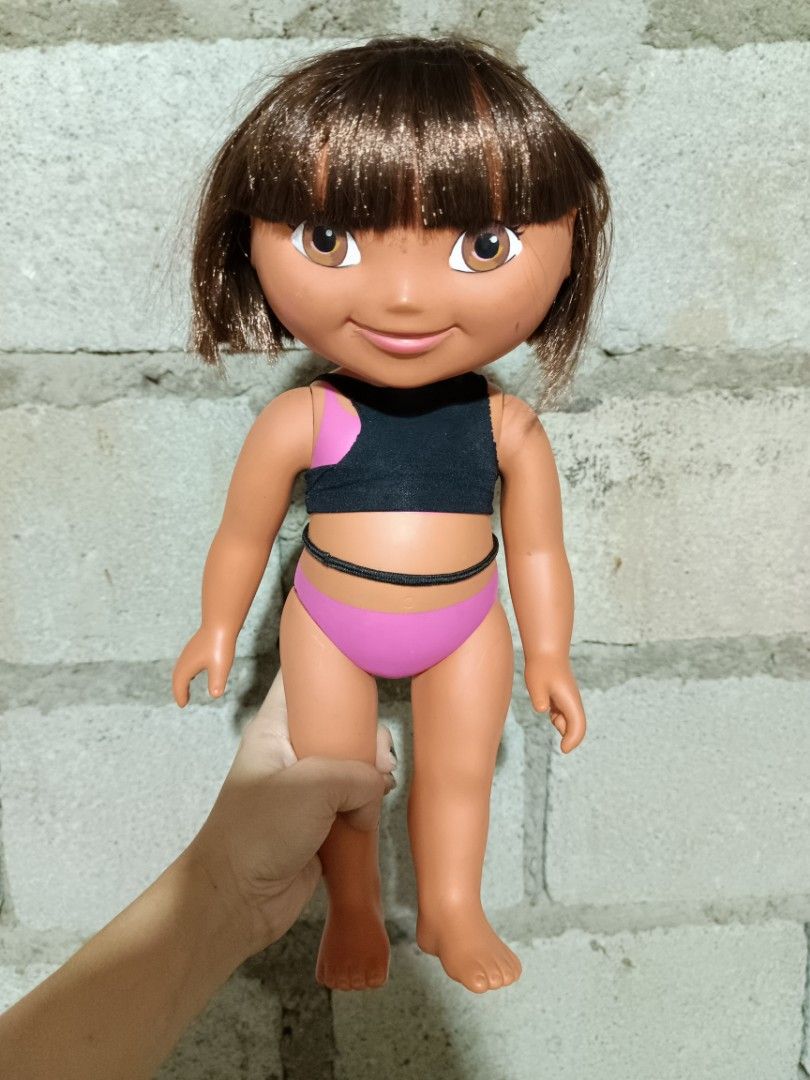2003 Mattel Dora the Explorer Doll (Category: Kids Toys) located in Manila. Submitted by caaths_collection (Listing ID 1444173349, Image 1). Description: - Dora the Explorer doll from 2003 - Manufactured by Mattel - Features brown hair and brown eyes - Dressed in a cute black and pink swimsuit - Minor scuffs present on the feet - Ideal for Dora collectors or for playtime fun - preloved.