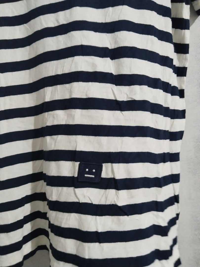 Acne Studios Striped T-Shirt with Face Logo (Category: Tshirts & Polo Shirts ) located in Tabaco. Submitted by strain_finds (Listing ID 1444206111, Image 2). Description: - Classic navy and white stripes - Acne Studios iconic face logo patch on chest - Comfortable 100% cotton fabric - Versatile for casual outfits - Pairs well with jeans or shorts.
