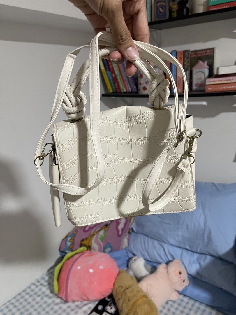 Cream Textured Knot Handle Shoulder Bag (Category: Shoulder Bags) located in Mandaluyong City. Submitted by ynsbf (Listing ID 1444247258, Image 3). Description: - Elegant cream-colored shoulder bag - Unique textured crocodile-like pattern - Stylish knot detail on top handles - Includes a long, adjustable strap for versatility - Secure front flap closure - Ideal for casual outings or dressing up your outfit - Perfectly fits your essentials: phone,