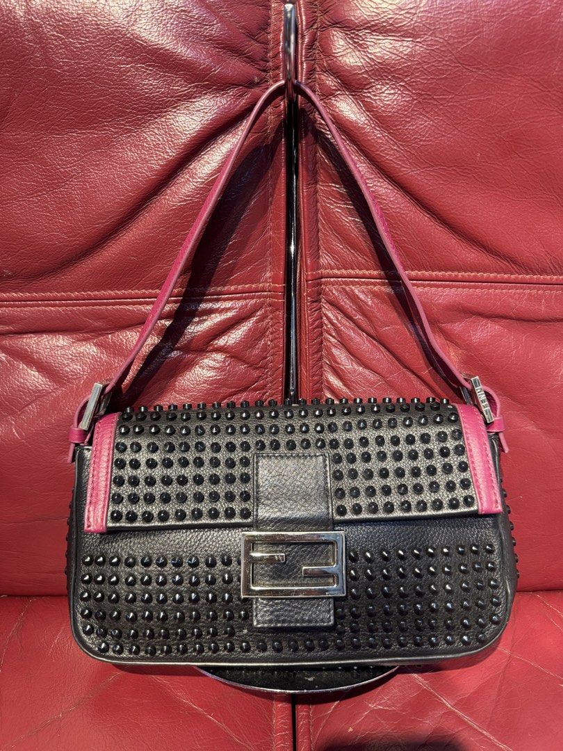 Fendi Black Studded Baguette Bag (Category: Luxury Bags & Wallets) located in Santiago. Submitted by twicebutnice03 (Listing ID 1444115612, Image 1). Description: - Classic Fendi Baguette style - Black leather with stud embellishments - Pink accents on strap and trim - Silver Fendi logo buckle closure - Versatile for day or night use Missing 2 stud From Japan Surplus.