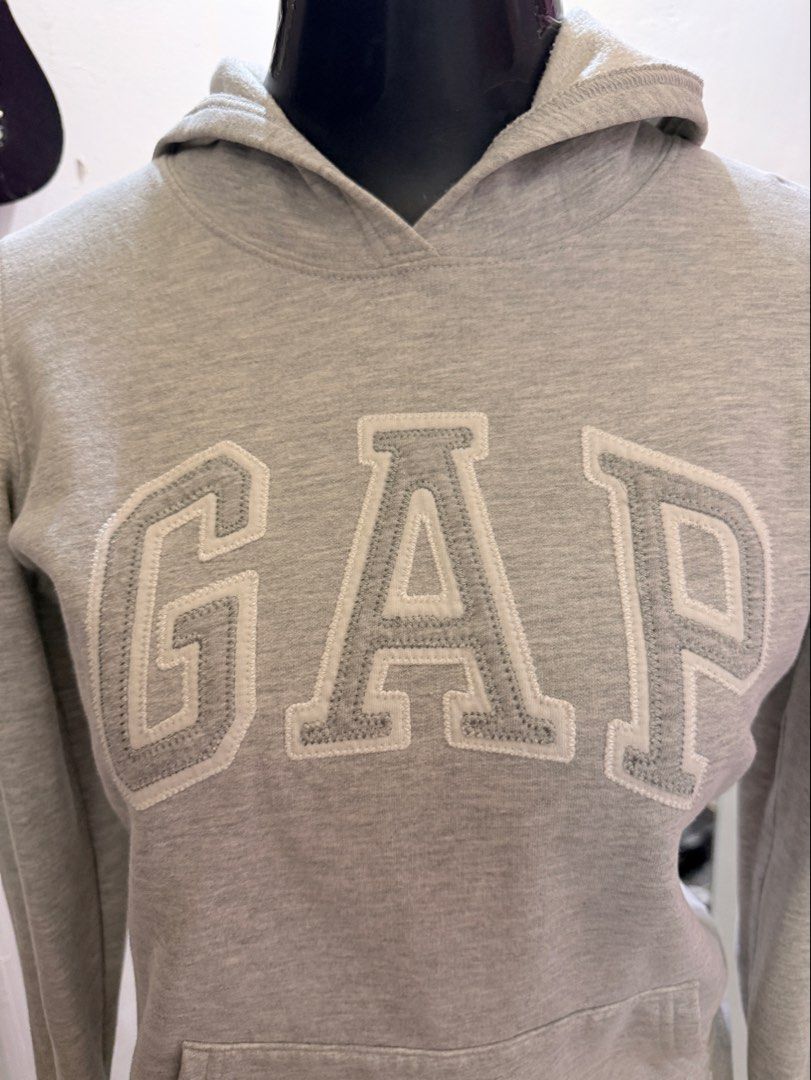 GAP Hoodie (Category: Coats, Jackets and Outerwear) located in Caloocan City. Submitted by prettyplease000 (Listing ID 1444281553, Image 2). Description: xs to small frame only no issue, like new na-buy sa HK NEGOTIABLE - Gray GAP hoodie - Classic white GAP logo on front - Front pocket - Hooded design - Made in Cambodia - Size XXS on tag.