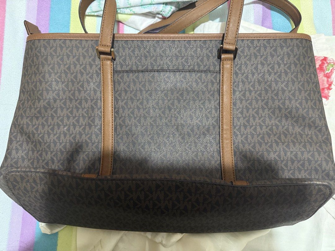 Michael Kors Monogram Tote Bag Brown (Category: Luxury Bags & Wallets) located in Cagayan de Oro. Submitted by tinp17 (Listing ID 1444255174, Image 2). Description: - Authentic Michael Kors tote bag - can fit the average sized laptop - Signature brown MK print - Tan leather trim and straps - Gold tone hardware with MK charm - Spacious interior with pockets - Includes care card and tech accessory info card - Ideal for everyday use Rfs: very seldom