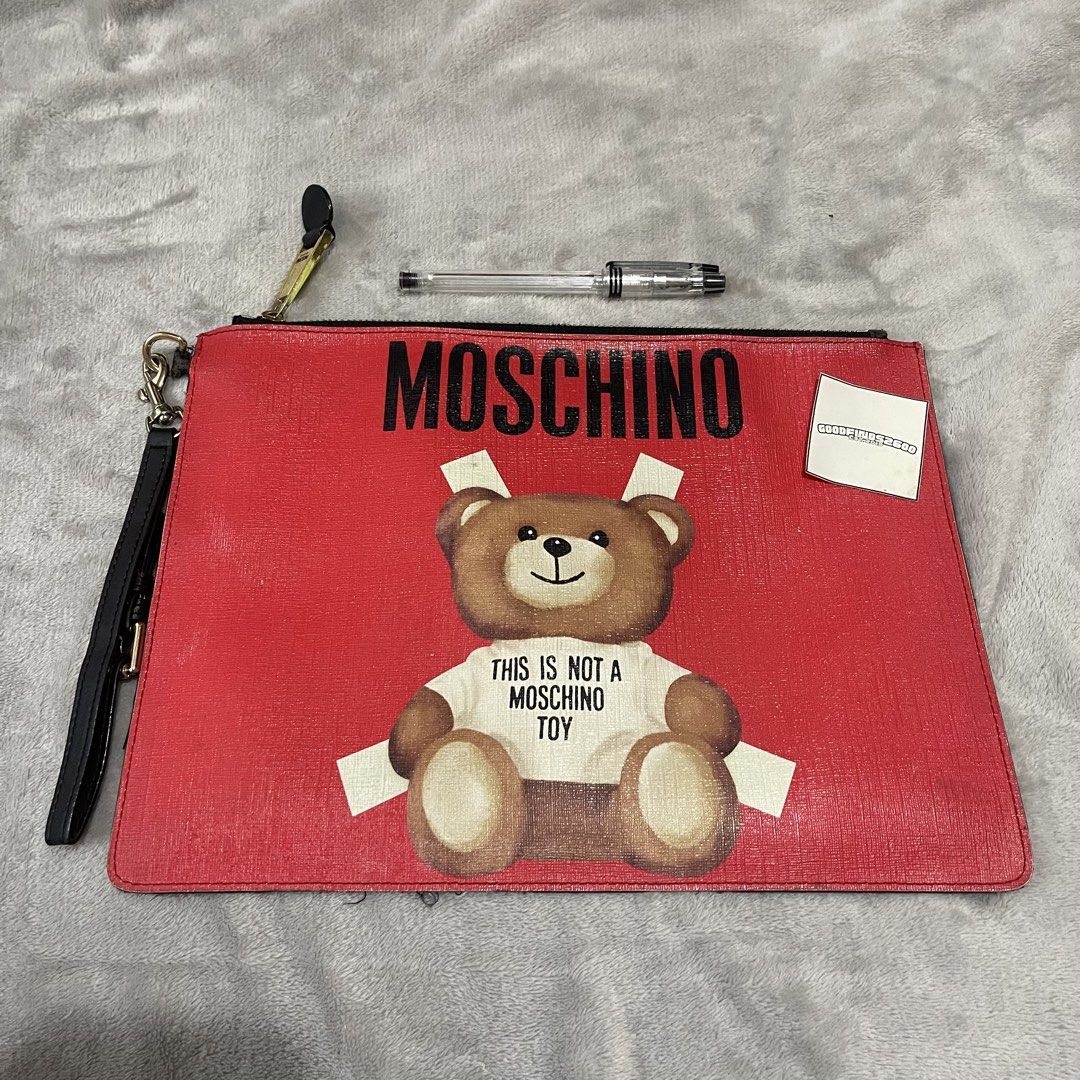 Moschino Saffiano Leather Clutch Pouch (Category: Luxury Bags & Wallets) located in Baguio. Submitted by goodfinds2600v2 (Listing ID 1444267797, Image 2). Description: Size on tag: Dimensions: L- W- Description: Condition: Very good Issue/s: signs of usage, light fade on leather(some parts), needs replacement on wrist handle attachment .