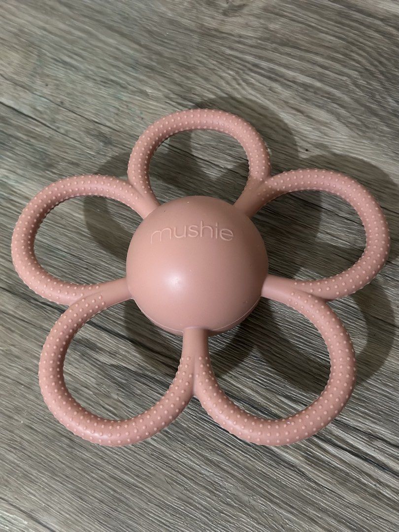 Mushie Silicone Daisy Rattle Flower Teether Rose Pink (Category: Soothers & Pacifiers) located in Bulacan. Submitted by tinparco (Listing ID 1444133073, Image 3). Description: 🩷Good as new 🩷Authentic Mushie product 🩷Gently used and thoroughly cleaned.🩷Made from soft, textured silicone. 🩷Easy for babies to grip. 🩷Soothes sore gums during teething. .