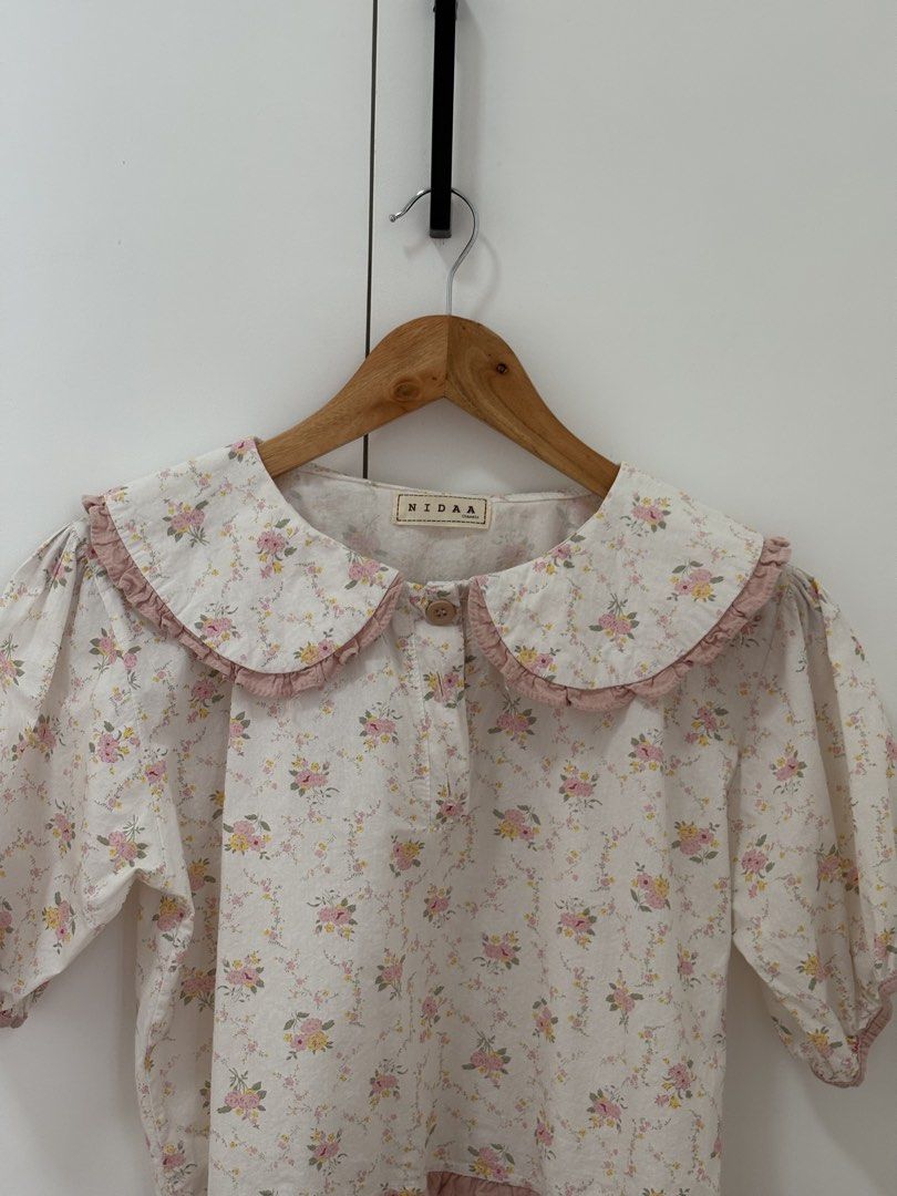 NIDAA Floral Peter Pan Collar Puff Sleeve Top (Category: Blouses) located in Bacoor. Submitted by pretticel (Listing ID 1444140582, Image 2). Description: - Cream top with charming pink floral print - Features a large, ruffled Peter Pan collar - Sweet puff sleeves for a feminine touch - Easy button-front closure - Flattering ruffled hemline - Perfect for a vintage-inspired outfit.