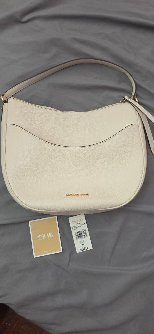 Original Michael Kors White Leather Crescent Shoulder Bag (Category: Shoulder Bags) located in Pasig City. Submitted by lfboutique (Listing ID 1444194776, Image 1). Description: - original lightly used Michael Kors off white leather shoulder bag - Stylish curved crescent shape - Secure zip closure - Interior features a zip pocket and slip pockets for organization - Elegant gold hardware details - Comes with original tags and authenticity card - I