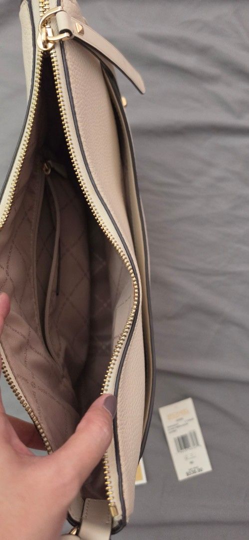 Original Michael Kors White Leather Crescent Shoulder Bag (Category: Shoulder Bags) located in Pasig City. Submitted by lfboutique (Listing ID 1444194776, Image 2). Description: - original lightly used Michael Kors off white leather shoulder bag - Stylish curved crescent shape - Secure zip closure - Interior features a zip pocket and slip pockets for organization - Elegant gold hardware details - Comes with original tags and authenticity card - I