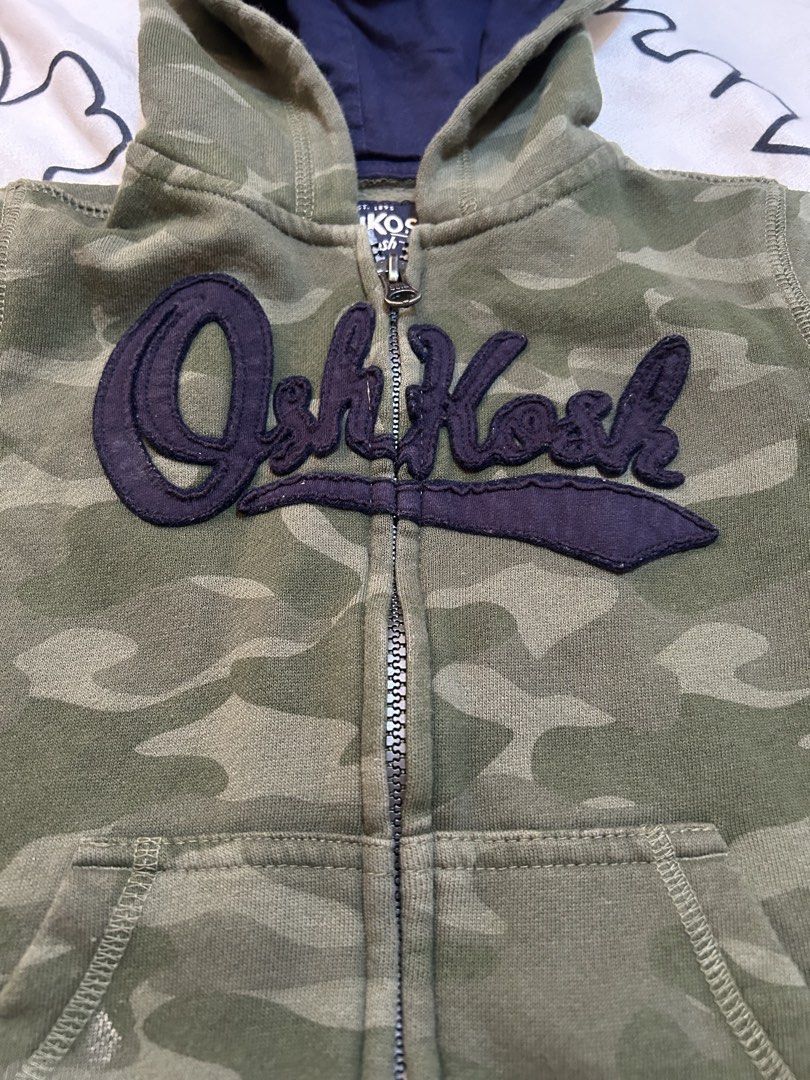 OshKosh Camouflage Jacket Hoodie, 4y (Category: Babies & Kids Fashion) located in Paranaque City. Submitted by allthatclutterph (Listing ID 1444176702, Image 3). Description: - OshKosh camo zip-up hoodie (Size 4) with navy lined hood Very good condition as seldom used.