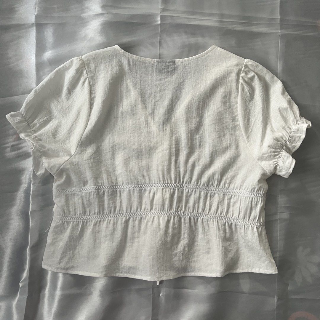 PENSHOPPE Puff Sleeve Blouse Top (Category: Blouses) located in Antipolo. Submitted by lacekeepsakes (Listing ID 1444190631, Image 2). Description: 🌷 condition: good, previously used. 🌷 design details: front tie details; peplum hem; smocked/elasticized waist;puff sleeves 🌷 fabric: likely woven cotton blend or rayon-cotton blend 🌷 material: not confirmed from available sources 🌷 color: off-white 🌷 size: large 🌷 issues/flaws: none observed t