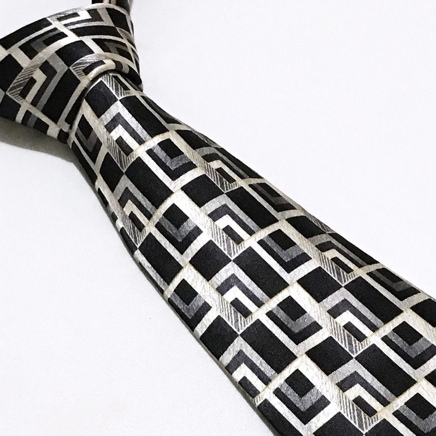 Pierre Cardin Black Geometric Neck Tie (Category: Ties) located in Taguig. Submitted by retrogaze (Listing ID 1444285760, Image 1). Description: This striking vintage necktie by Pierre Cardin masterfully embodies a retro-modernist, architectural aesthetic. This 100% silk accessory relies on a deep, black base that grounds the bold design. The fabric boasts a subtle textured quality that interacts beautifully with the light, granting the blade an 