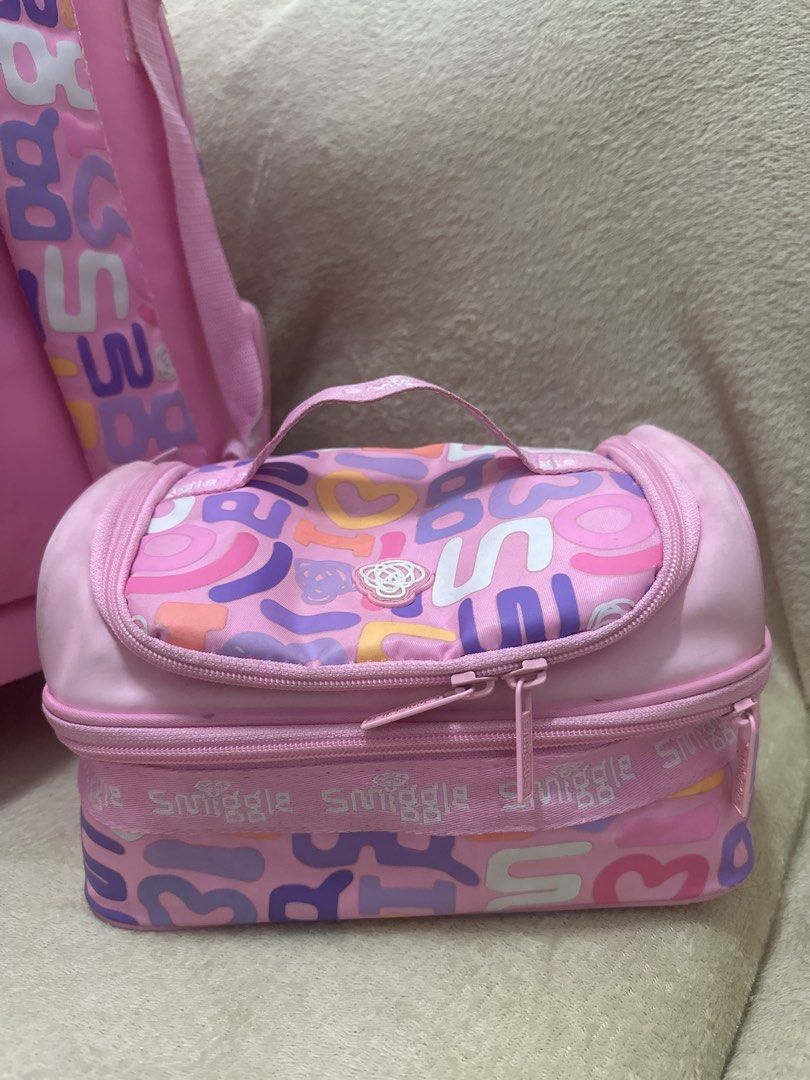 Smiggle Pink Rolling Backpack and Lunchbox Set (Category: Babies & Kids Fashion) located in Quezon City. Submitted by iamseahorse (Listing ID 1444255145, Image 2). Description: - Adorable pink Smiggle rolling backpack and matching lunchbox set. - Features a fun, colorful letter and heart pattern. - Backpack has wheels and a retractable pull handle for effortless transport. - Convenient side pockets, perfect for water bottles. - Lunchbox includes 