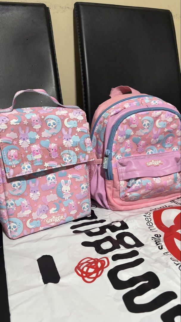 Smiggle Teeny Tiny Bag + Lunch Bag (Category: Babies & Kids Fashion) located in San Jose. Submitted by arakyer (Listing ID 1444238041, Image 1). Description: - Adorable Smiggle backpack and matching lunchbox set. - Features a fun pink print with bunnies, pandas, and moons. - Backpack includes a front pocket and side mesh pockets. - Lunchbox has a convenient handle and secure flap closure. - Ideal for school, daycare, or everyday adventures. - Bot