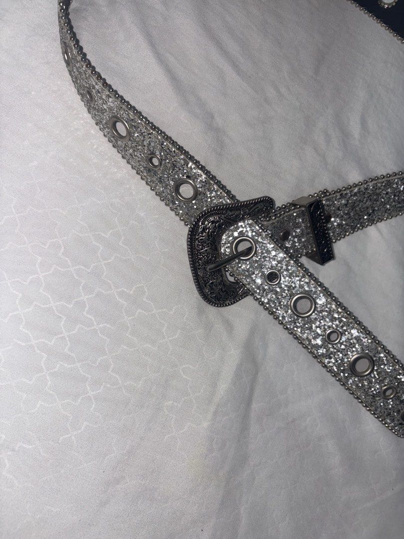 Sparkly Silver Glitter Belt with Buckle (Category: Belts) located in Manila. Submitted by thriftgodesa (Listing ID 1444276219, Image 2). Description: - Eye-catching silver glitter belt - Features a cool, ornate buckle - Multiple eyelets for adjustable and customizable sizing - Adds instant sparkle to any outfit - Versatile: looks great with jeans and dresses.