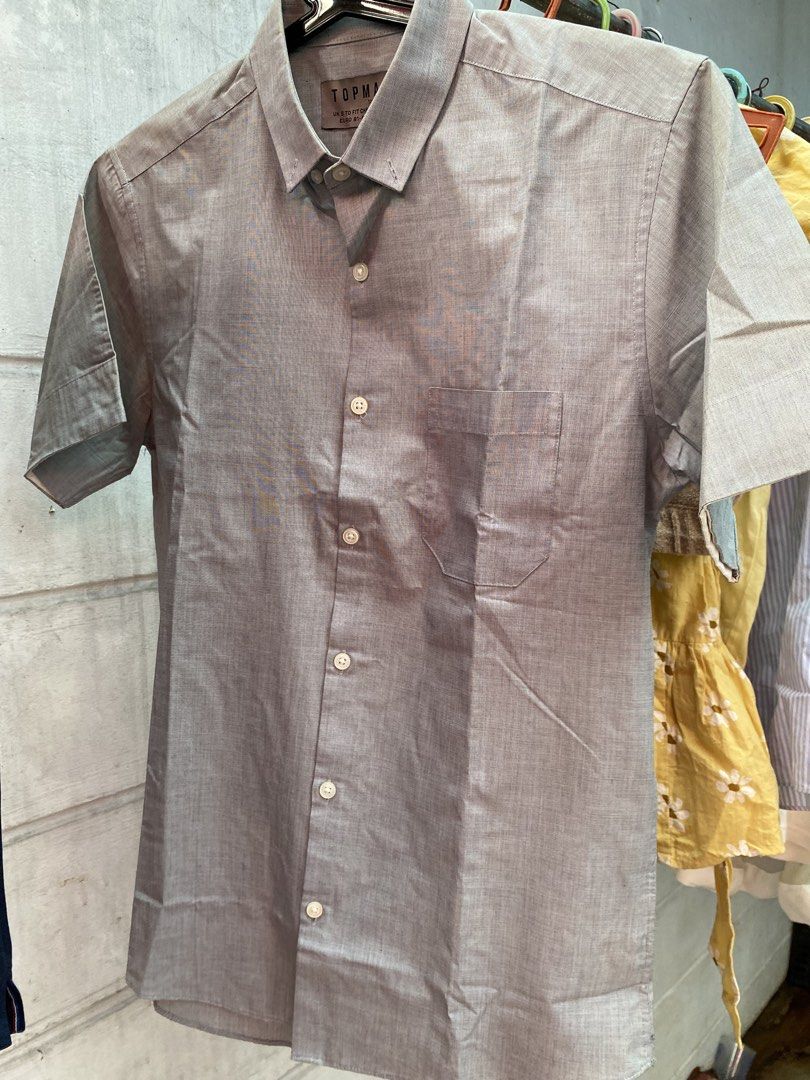TOPMAN Grey Short Sleeve Button Up Shirt Size S (Category: Tshirts & Polo Shirts ) located in Quezon City. Submitted by maodg (Listing ID 1444249033, Image 1). Description: - Brand: TOPMAN - Color: Grey - Style: Short sleeve, button-up shirt - Features: Chest pocket - Origin: Made in Bangladesh - Size: S - Chest Fit: 36-38 inches - Occasion: Casual or smart casual wear - Condition: Please check photos for details Location: Scout area in Kamuning 