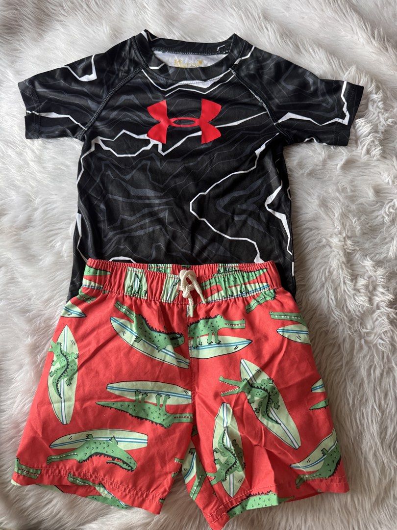 Under Armour Rash Guard & Old Navy Swim Trunks Set (Category: Babies & Kids Fashion) located in Quezon City. Submitted by amcadona (Listing ID 1444298281, Image 1). Description: - Under Armour rash guard: Black and white lightning pattern with red logo. - Old Navy swim trunks: Red base with green alligator and surfboard print. - Swim trunks feature an elastic waistband with a drawstring for a secure fit. - Ideal for beach days, pool parties, or a