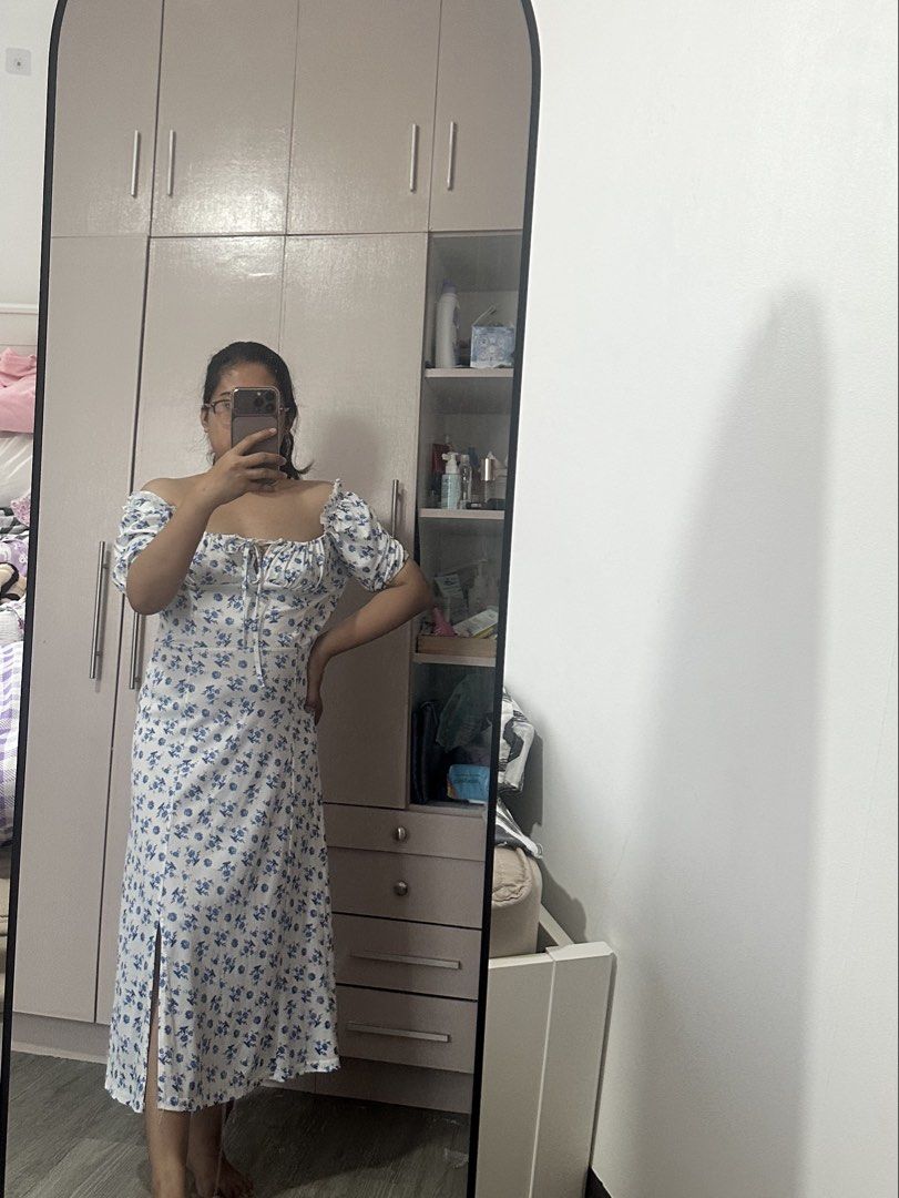 White Floral Dress (Category: Dresses) located in Quezon City. Submitted by gracejongin88 (Listing ID 1444131312, Image 1). Description: - White midi dress with a charming blue floral print. - fits M frame - Features stylish puff sleeves. - Flattering tie-front detail at the bust. - Includes a chic side slit for added flair. - Versatile and easy to style for casual outings or a day out..
