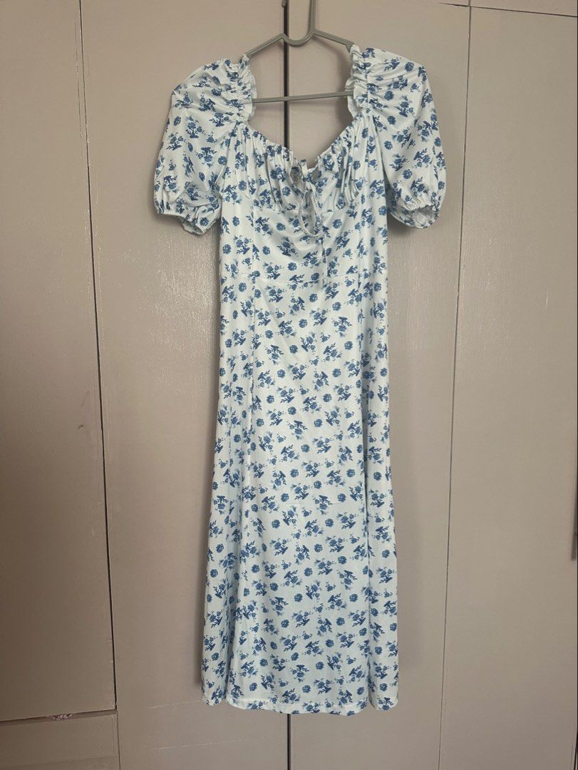 White Floral Dress (Category: Dresses) located in Quezon City. Submitted by gracejongin88 (Listing ID 1444131312, Image 2). Description: - White midi dress with a charming blue floral print. - fits M frame - Features stylish puff sleeves. - Flattering tie-front detail at the bust. - Includes a chic side slit for added flair. - Versatile and easy to style for casual outings or a day out..