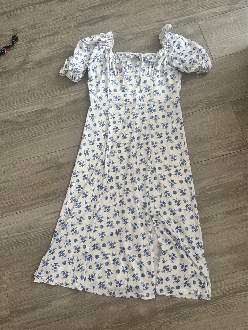 White Floral Dress (Category: Dresses) located in Quezon City. Submitted by gracejongin88 (Listing ID 1444131312, Image 3). Description: - White midi dress with a charming blue floral print. - fits M frame - Features stylish puff sleeves. - Flattering tie-front detail at the bust. - Includes a chic side slit for added flair. - Versatile and easy to style for casual outings or a day out..