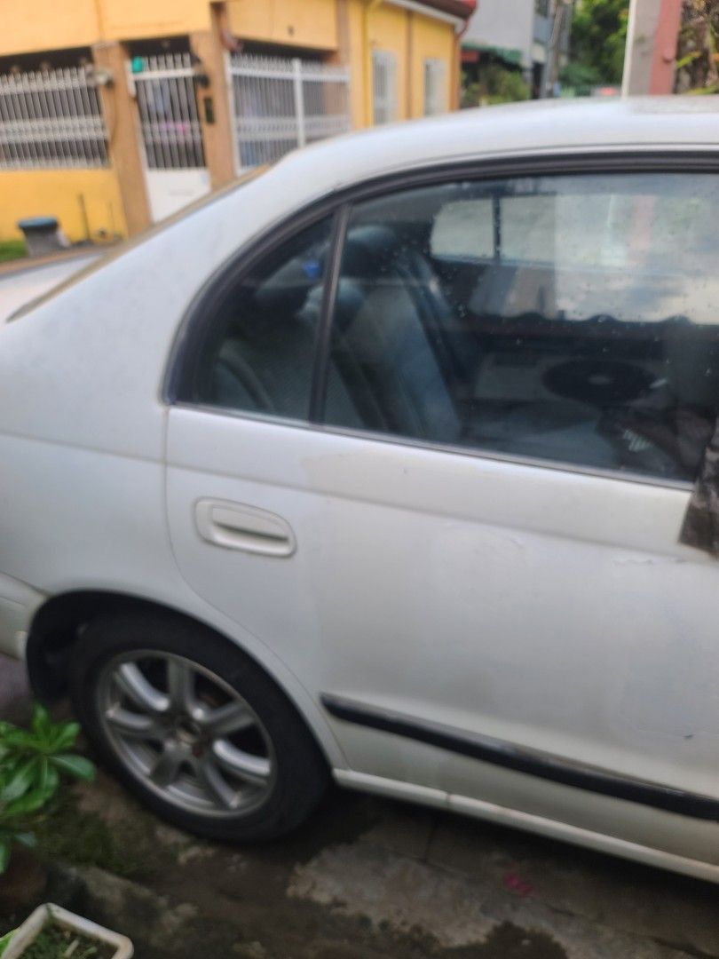 Toyota Corona (Category: Used Cars) located in Quezon City. Submitted by veegee1216 (Listing ID 1444162997, Image 3). Description: Selling a white Toyota CORONA EXSIOR 1998 MODEL This car has a sporty look with a rear spoiler. Automatic transmission. License plate is visible in the photos. in running condition- cold AC NEWLY REPLACED BATTERY *NOT REGISTERED *1 passenger side AUTOMATIC WINDOWS NOT WORKING FREE TRINK MOUNTAIN BIKE STILL GOOD BUT GO