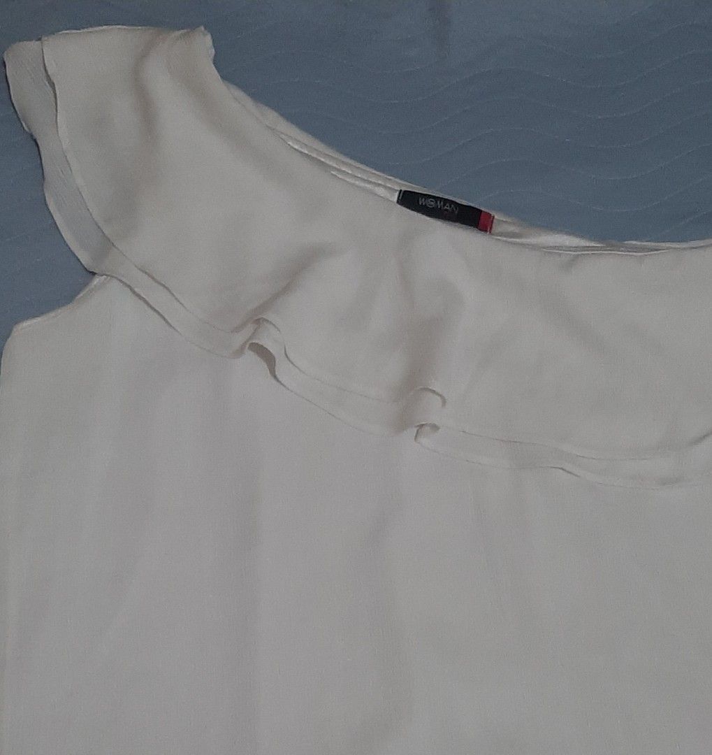 Woman Plus White One Shoulder Ruffle Top (Category: Sleeveless) located in Pasig City. Submitted by daffydaff (Listing ID 1444246636, Image 2). Description: - White one-shoulder top - Ruffle detail across the chest - Brand: Woman Plus - Minor flaw: Small mark inside (circled in last photo-unnoticeable) - Condition: Good - Plus size: 1L.