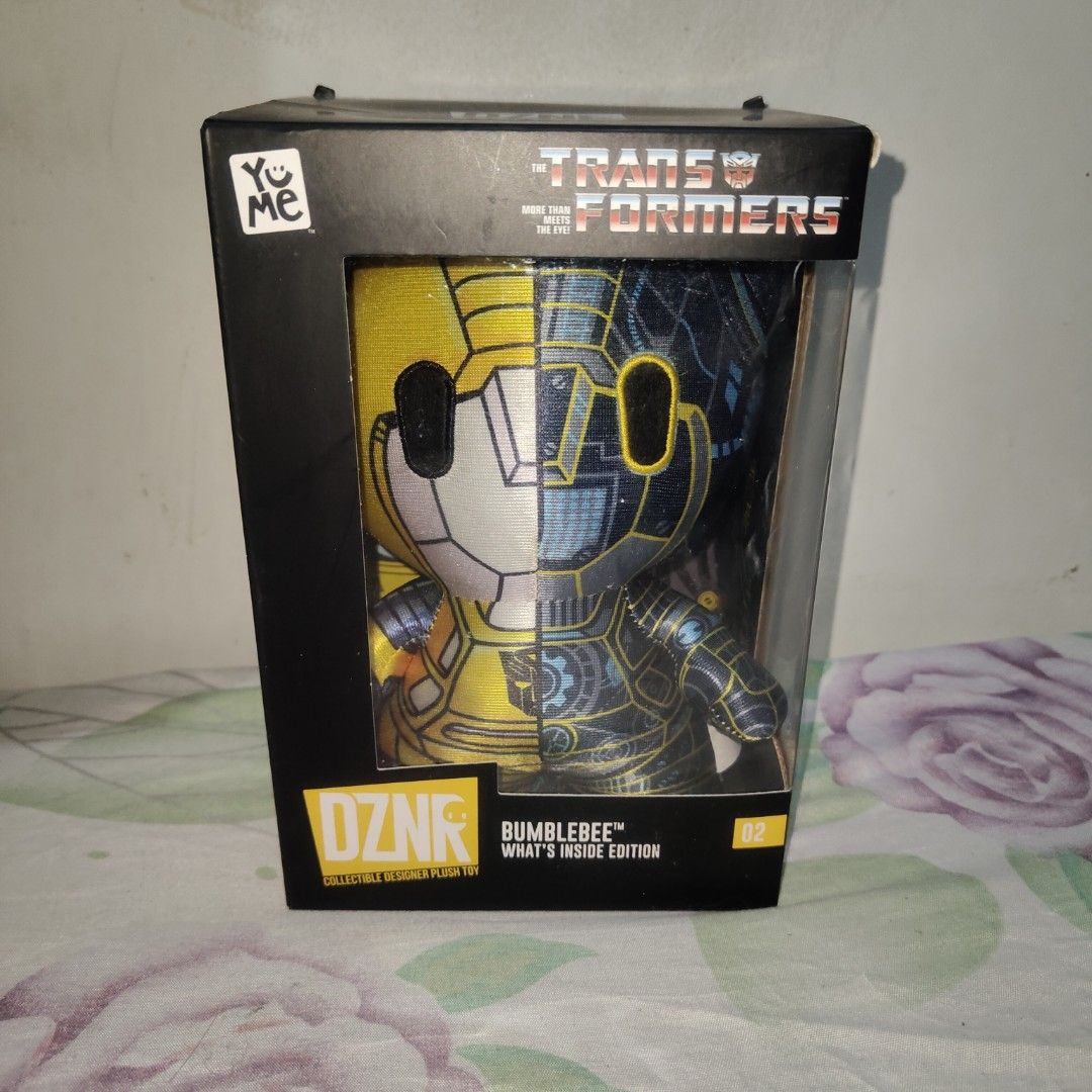 YuMe Transformers DZNR Bumblebee What's Inside Edition Plush (Category: Plushies & Soft Toys) located in Quezon City. Submitted by patric1218 (Listing ID 1444275769, Image 1). Description: - YuMe DZNR Transformers Bumblebee Plush - 'What's Inside Edition', Number 02 - Unique split design: shows both robot and car modes - Comes in original packaging - Ideal for any Transformers collector or fan.