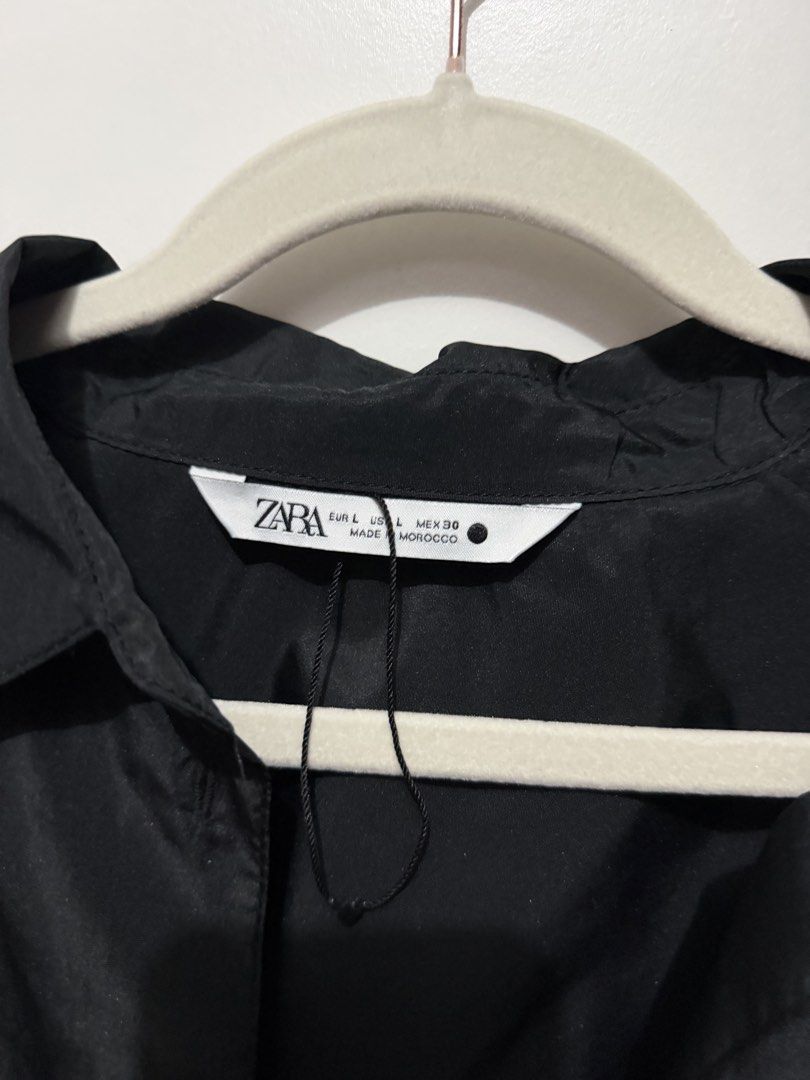 Zara Black Cropped Oversized Shirt Jacket (Category: Shirts) located in Manila. Submitted by deklutterph (Listing ID 1444284065, Image 2). Description: - Zara black shirt - Cropped and oversized fit - Button-up front with collar - Long sleeves with elasticated cuffs - Lightweight material - Versatile for layering or wearing solo.