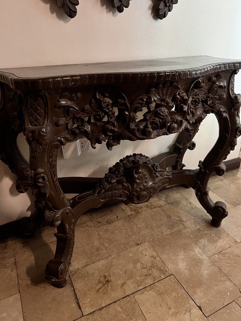 Antique Dark Wood Console Table with Ornate Mirror (Category: Tables & Sets) located in Paranaque City. Submitted by ohjustdecluttering (Listing ID 1444398643, Image 2). Description: - Beautifully carved dark wood console table and matching mirror set. - Features intricate floral and scroll details. - Table has a curved top and ornate legs. - Mirror has a highly decorative frame. - Adds vintage charm to any space. - Ideal for entryways or hallway