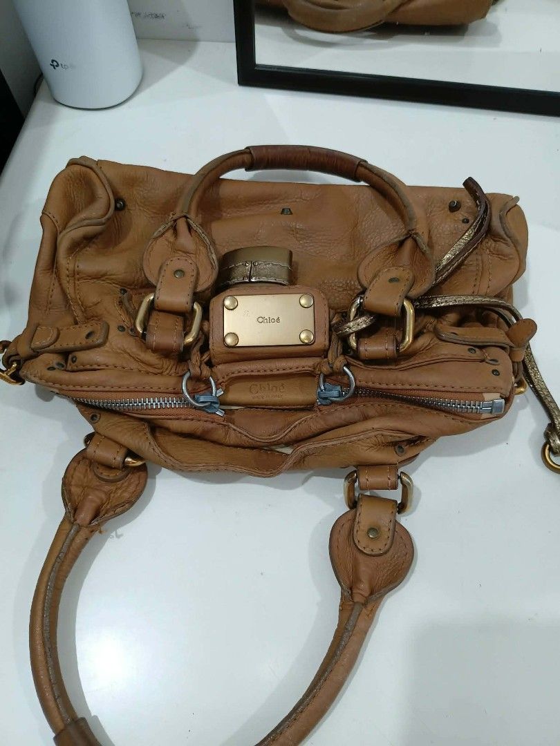 Authentic Chloe Paddington Satchel bag (Category: Luxury Bags & Wallets) located in Quezon City. Submitted by jäckpötjöy (Listing ID 1444344744, Image 2). Description: - Authentic Chloe Paddington bag - Color: Tan leather - Iconic padlock detail with key charm - Top handles - Zip closure - Fabric interior lining - Shows some signs of wear on leather and interior - A classic and timeless piece A well-preserved piece featuring beautifully aged leat