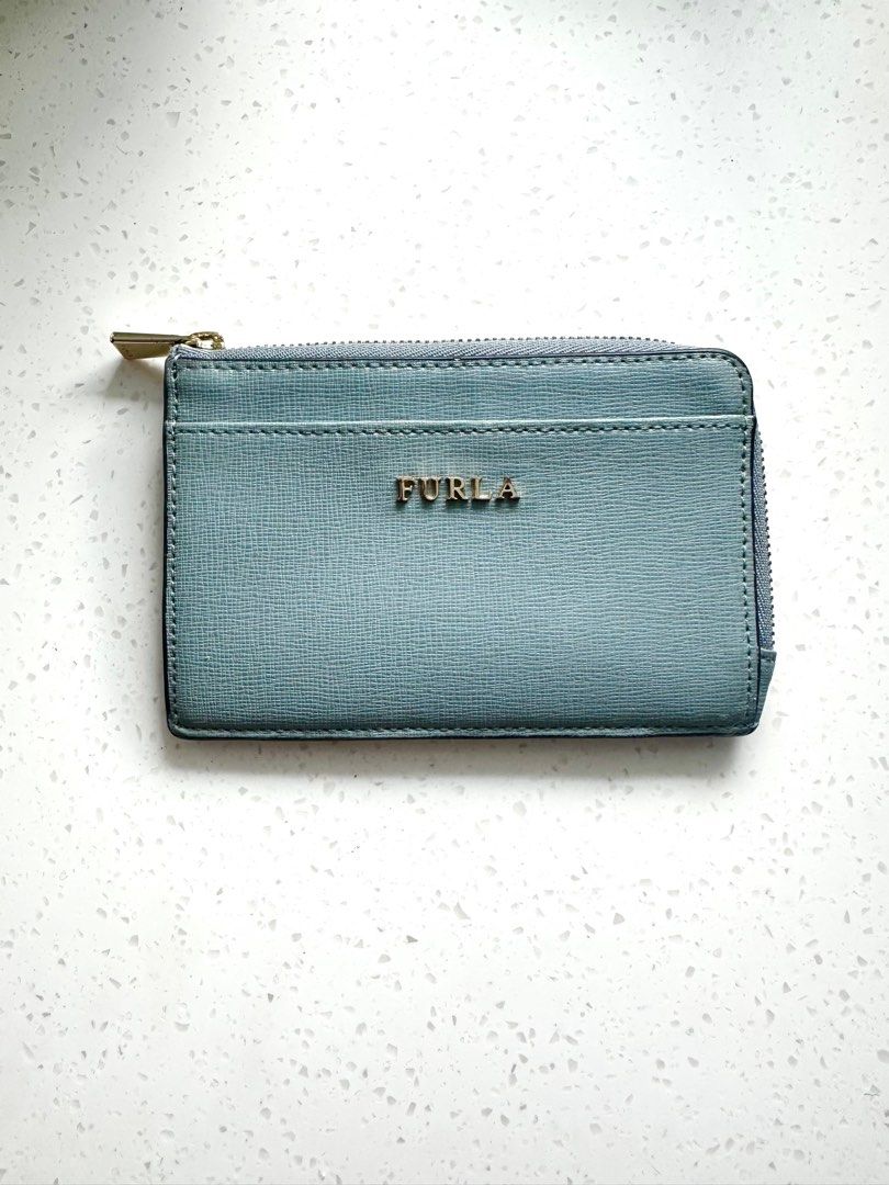 Furla Genuine Leather Cardholder (Category: Wallets & Card holders) located in Quezon City. Submitted by nancdmd (Listing ID 1444426997, Image 1). Description: Light blue Furla cardholder. Made of genuine leather. Has a zip closure and a front slip pocket. Also features card slots on the back. Gold hardware details. Compact and practical for everyday use..