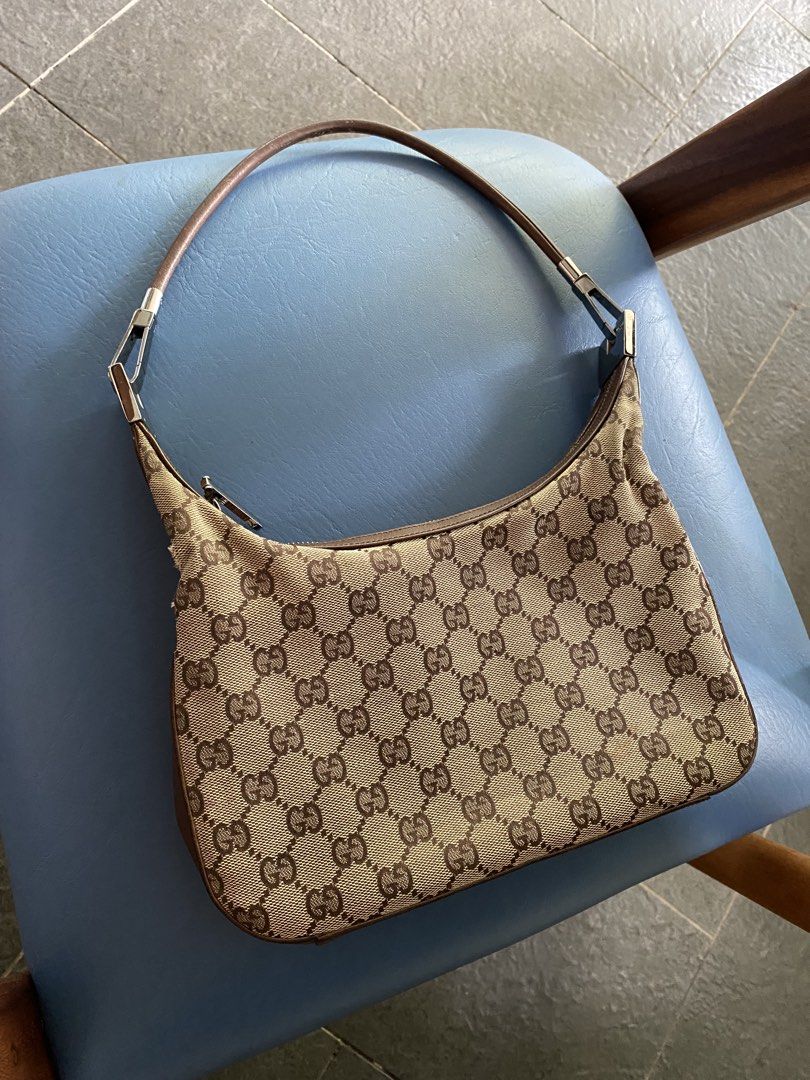 SALE! Gucci Monogram Canvas Mini Hobo (Category: Luxury Bags & Wallets) located in Santa Rosa. Submitted by happydays__ (Listing ID 1444319890, Image 2). Description: - Classic Gucci canvas mini hobo shoulder bag - Iconic GG monogram canvas - Brown leather trim and strap - Zipper closure - Interior zip pocket - some signs of wear on leather strap and trim.
