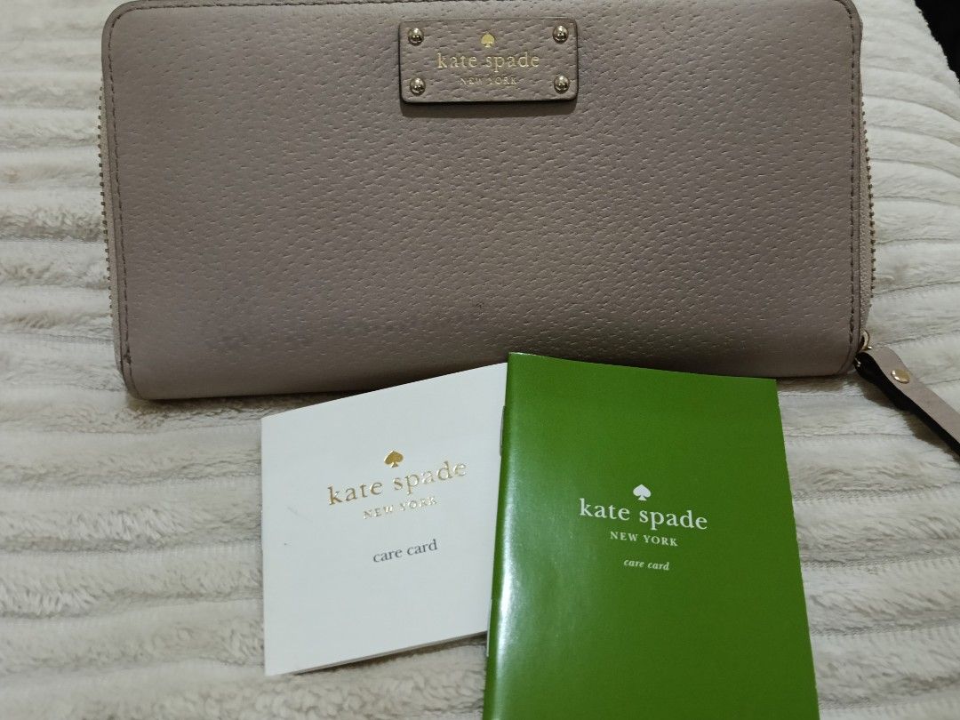 Kate Spade Zip Around Wallet (Category: Wallets & Card holders) located in Lapu Lapu. Submitted by tanvm1221 (Listing ID 1444403996, Image 1). Description: - Authentic Kate Spade zip-around wallet - Color: Neutral Taupe - Material: Pebble Leather - Features: Zipper closure, attached wristlet strap - Interior: Ample space for cards and cash - Includes: Care cards - Ideal for: Everyday use.