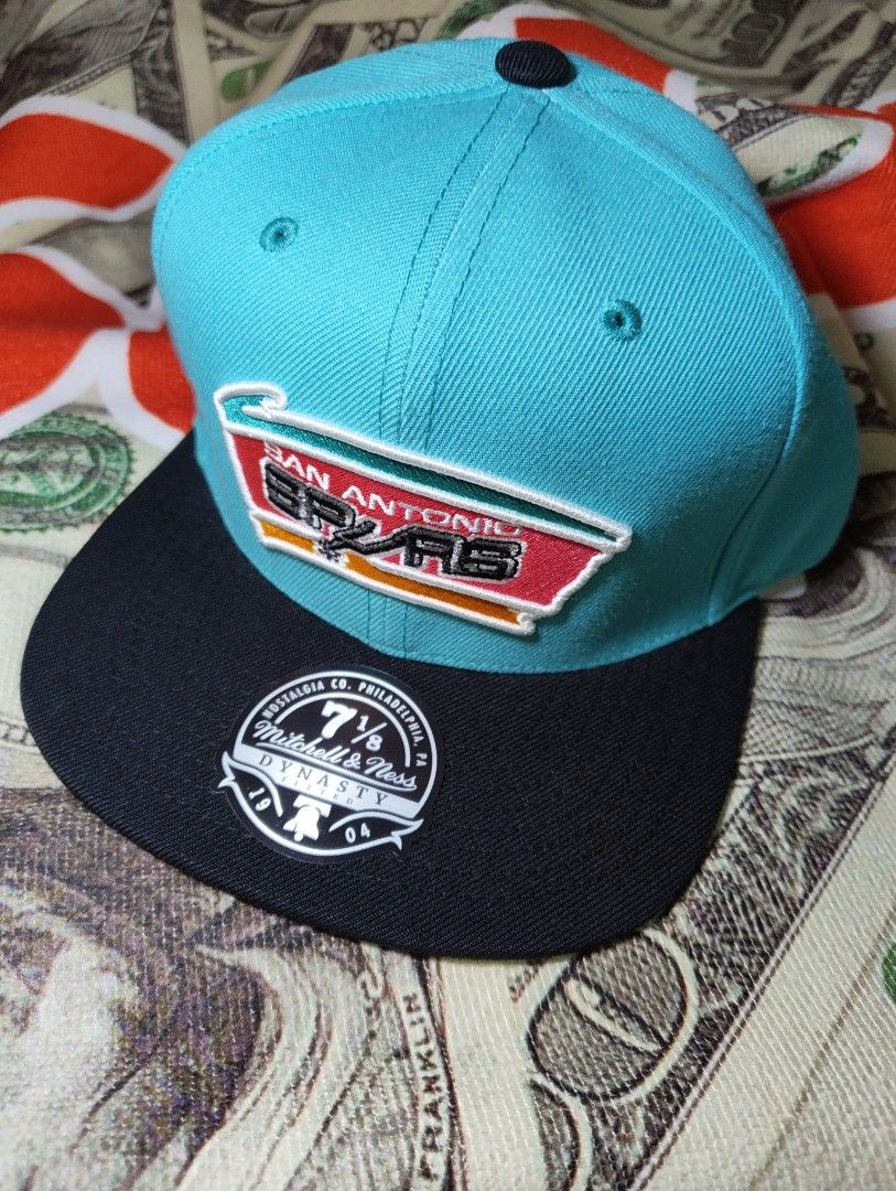 Mitchell & Ness San Antonio Spurs Snapback Cap (Category: Caps & Hats) located in Quezon City. Submitted by 0nestopshop (Listing ID 1444483367, Image 1). Description: - San Antonio Spurs snapback cap - Brand: Mitchell & Ness - Colorway: Teal and Black - Features classic Spurs logo on front - Size: 7 1/8 - Part of the Dynasty Fitted Collection - Perfect for any Spurs fan! ‼️PAUBOS STEAL BAWAS STOCK‼️ 7 1/8 polyester materials 60 USD ‼️1,200 na lng