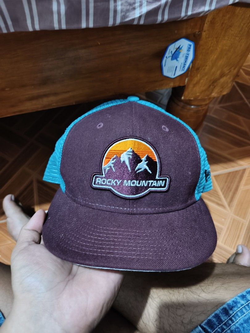 New Era 9FIFTY Rocky Mountain Trucker Cap (Category: Caps & Hats) located in Manila. Submitted by dyastenthrift (Listing ID 1444409800, Image 1). Description: - Brand: New Era - Style: 9FIFTY Trucker Cap - Design: Rocky Mountain patch on front - Colorway: Maroon front panels & brim, turquoise mesh back - Closure: Adjustable snapback - Size: Medium-Large (M-L) - Ideal for: Outdoor adventures, casual wear 600+sf or best offer.