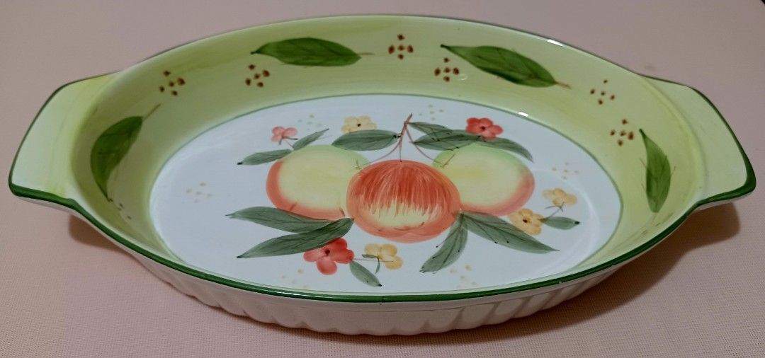 Oval Ceramic Dish with Fruit Design (Category: Bakeware) located in Quezon City. Submitted by wjmae (Listing ID 1444380077, Image 1). Description: - Oval ceramic baking dish - Hand-painted fruit and leaf design - Light green rim and handles - Ribbed exterior - Ideal for serving - Dimensions: Approx. 14 inches long x 9 inches wide.
