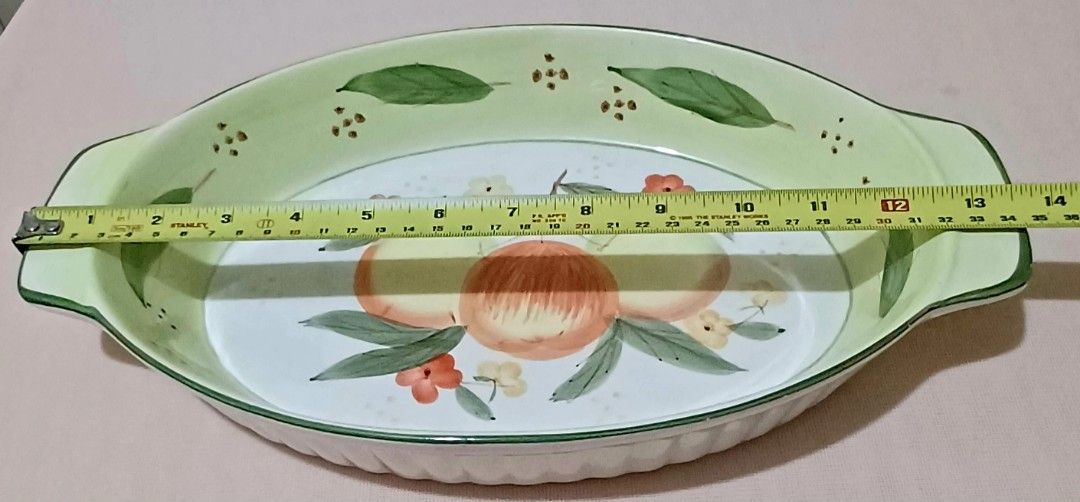 Oval Ceramic Dish with Fruit Design (Category: Bakeware) located in Quezon City. Submitted by wjmae (Listing ID 1444380077, Image 3). Description: - Oval ceramic baking dish - Hand-painted fruit and leaf design - Light green rim and handles - Ribbed exterior - Ideal for serving - Dimensions: Approx. 14 inches long x 9 inches wide.