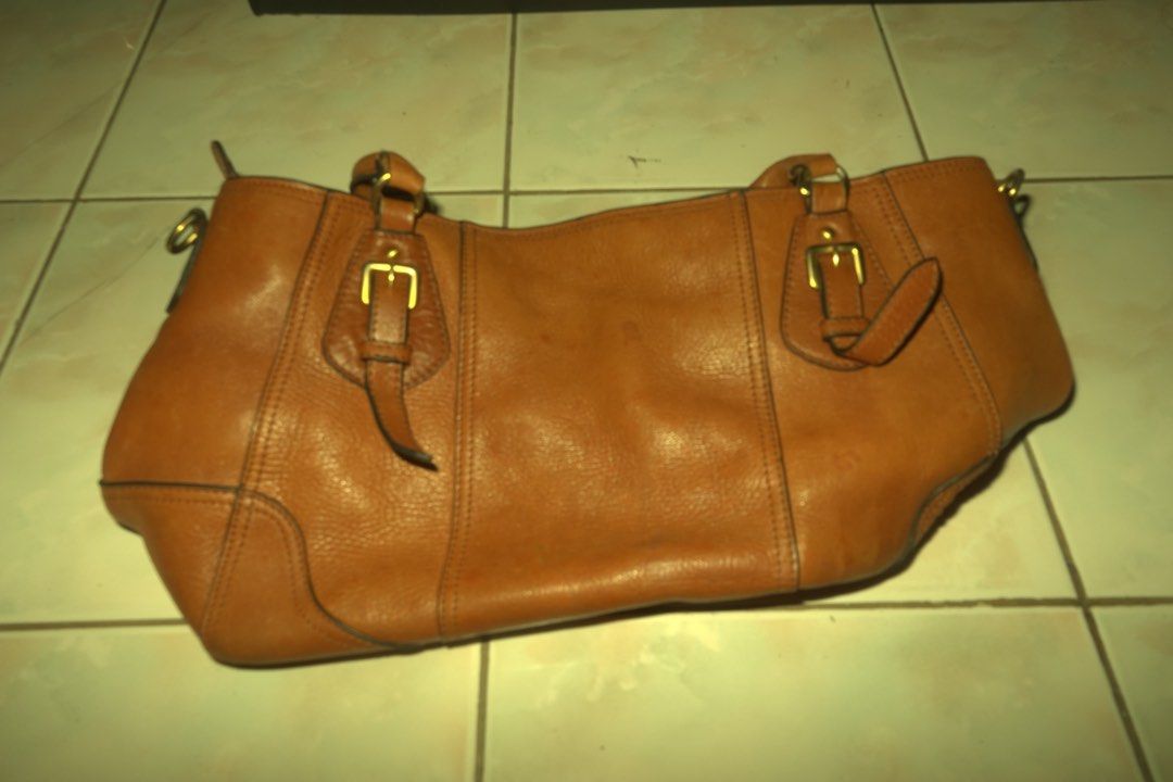 Prada Brown Leather Tote Bag (Category: Luxury Bags & Wallets) located in Manila. Submitted by noooneeee99 (Listing ID 1444406837, Image 2). Description: Bought it from Thailand for 7k. Prada bag. Made of brown pebbled leather. Has a spacious interior with a zip pocket. Gold hardware details. Some signs of wear on the bottom corners, as pictured. A classic everyday bag. Theres a water mark on the bottom. .