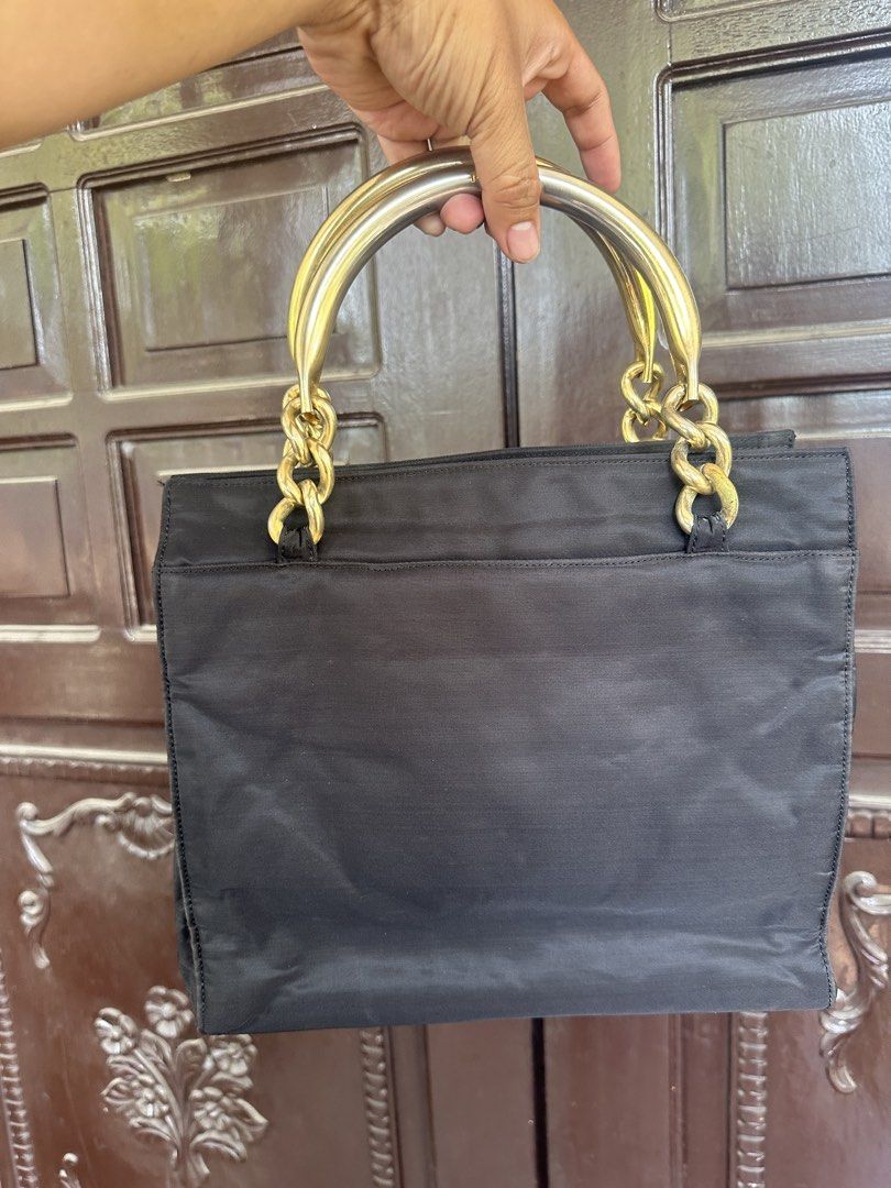 Prada Nylon Handbag with Gold Chain Handles (Category: Luxury Bags & Wallets) located in Bustos. Submitted by theprelovedshopbulacan (Listing ID 1444312631, Image 3). Description: - Authentic Black Prada Nylon Handbag - Elegant Gold Chain and Metal Handles - Signature Prada Triangle Logo on Front - Spacious Interior for Essentials - Perfect for Daily Use or Special Occasions - A Timeless Prada Accessory.