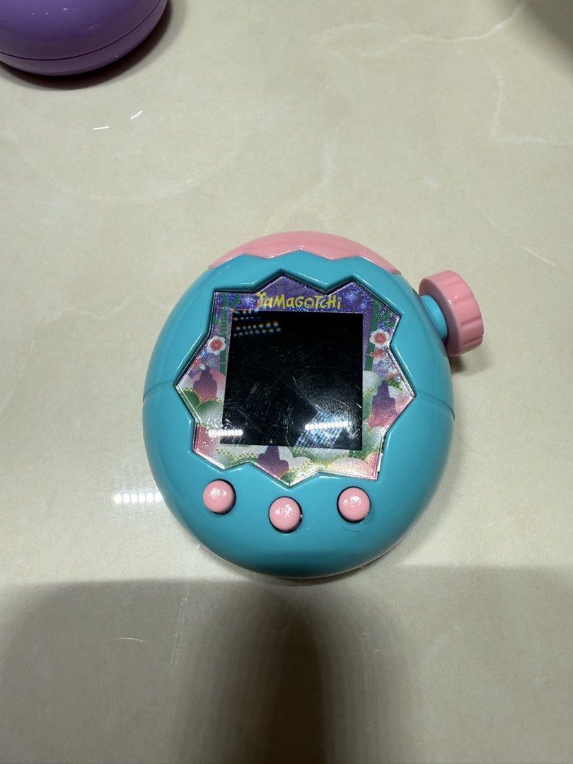 Purple Tamagotchi Virtual Pet Toy (Category: Interactive Toys) located in Singapore. Submitted by raisa.hassan.98 (Listing ID 1444441584, Image 2). Description: - Classic purple and blue Tamagotchi virtual pet. Bought 1 week ago. - Features pink buttons and top - Black and white screen - Fun retro digital toy - Perfect for collectors and retro gaming fans.