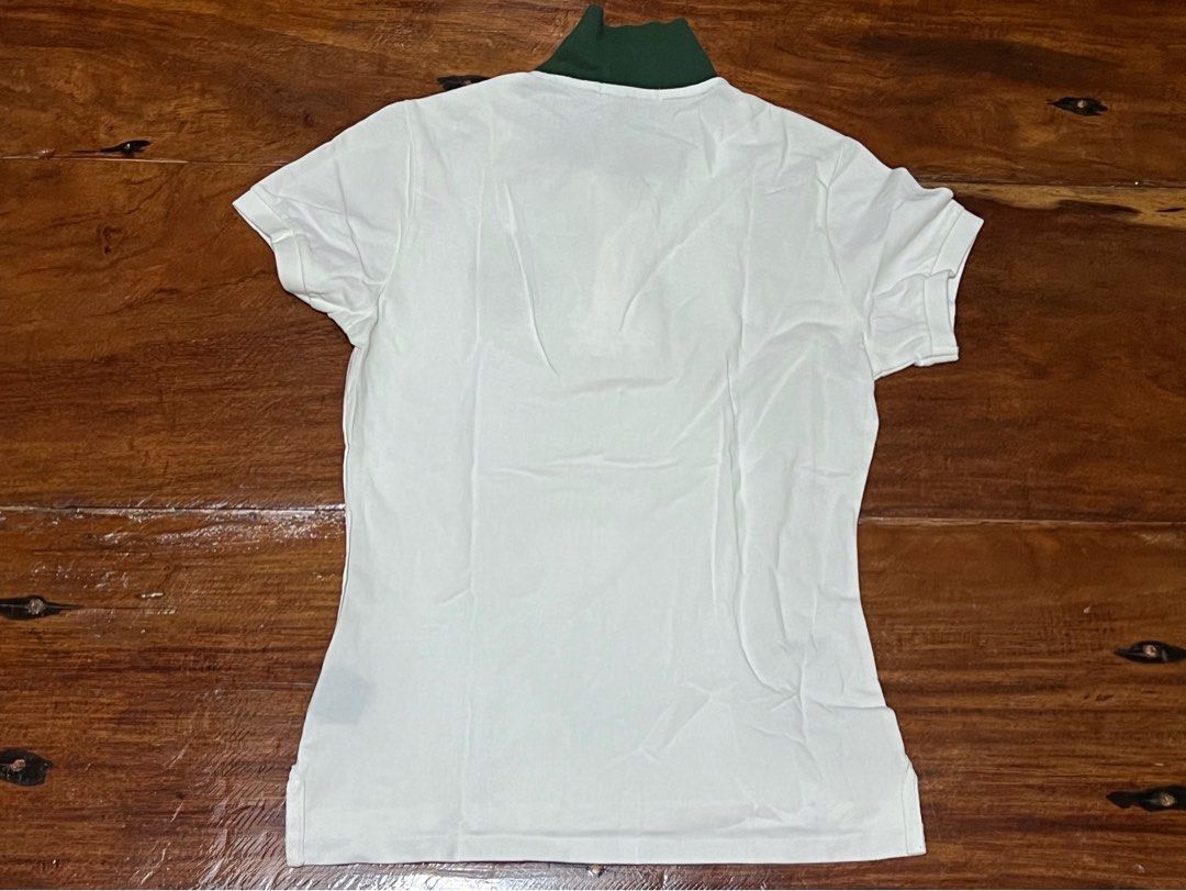 Ralph Lauren Polo Shirt (Category: Blouses) located in Leyte. Submitted by jcatle (Listing ID 1444362179, Image 2). Description: - Classic white Ralph Lauren polo shirt - Size: Large (L) on tag but fits xs-small - It has bleached stains on the collar. - Needs a wash - Short sleeves - Button-up neckline - Features iconic Ralph Lauren crest logo on chest - Green collar with minor discoloration - Material: 100% Cotton.