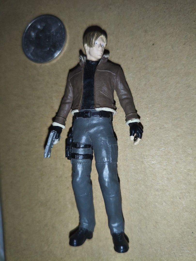 Resident Evil 4 Leon S. Kennedy Action Figure 3 inch (Category: Figurines & Statues) located in Manila. Submitted by v2Zuio (Listing ID 1444321933, Image 1). Description: - Resident Evil 4 Leon S. Kennedy action figure - Includes gun accessory and leg holster - Detailed outfit: brown jacket with fur collar, grey pants - Ideal collectible for Resident Evil enthusiasts - Approximately quarter-sized.