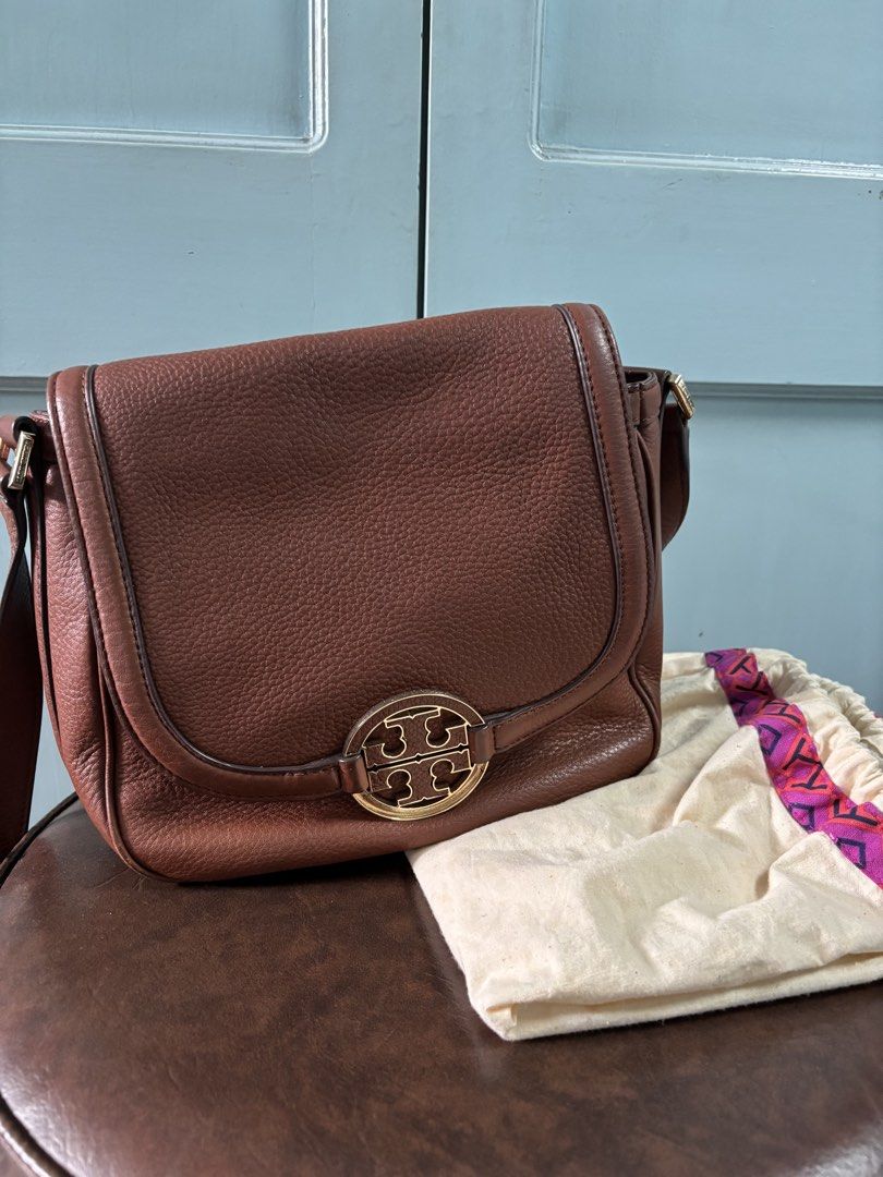 Tory Burch Amanda Brown Cross Body Bag (Category: Luxury Bags & Wallets) located in Manila. Submitted by mwhimsy (Listing ID 1444394160, Image 2). Description: - Brand: Tory Burch - Material: Genuine Brown pebbled leather - Design: Iconic gold double T logo on front flap - Interior: Patterned lining - Strap: Adjustable shoulder strap - Includes: Original dust bag - Ideal for: Everyday use - Authentic Tory Burch. Pre-loved.
