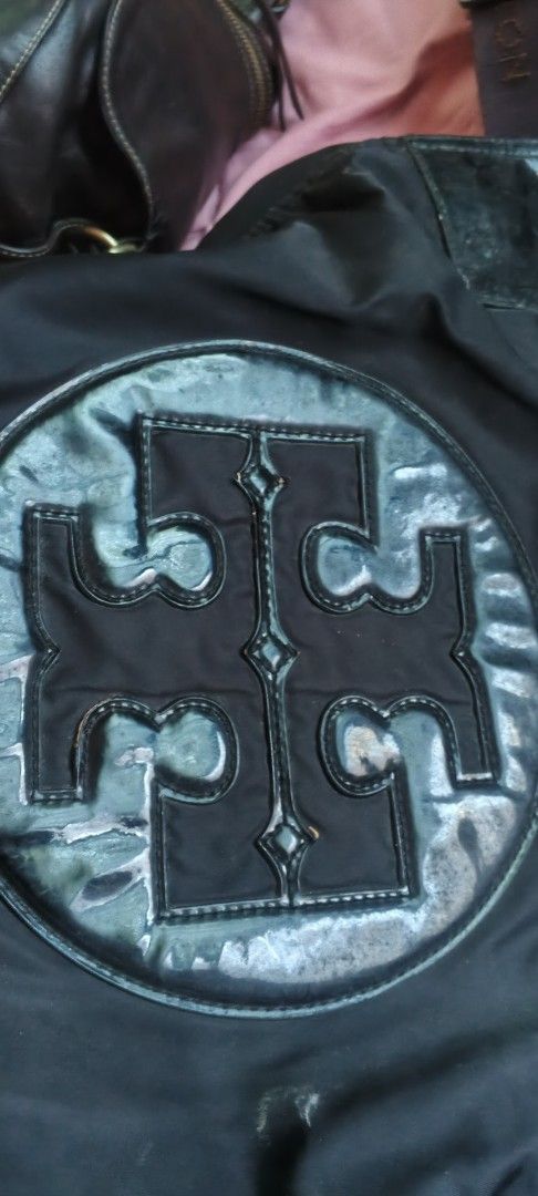 Tory Burch Black Nylon & Leather Tote Bag (Category: Luxury Bags & Wallets) located in Dasmarinas. Submitted by MVB0505 (Listing ID 1444332886, Image 2). Description: - Brand: Tory Burch - Color: Black - Material: Durable nylon with leather accents - Design: Iconic Tory Burch logo on the front - Interior: Multiple pockets for excellent organization - Hardware: Elegant gold details - Versatile: Ideal for everyday use or travel....