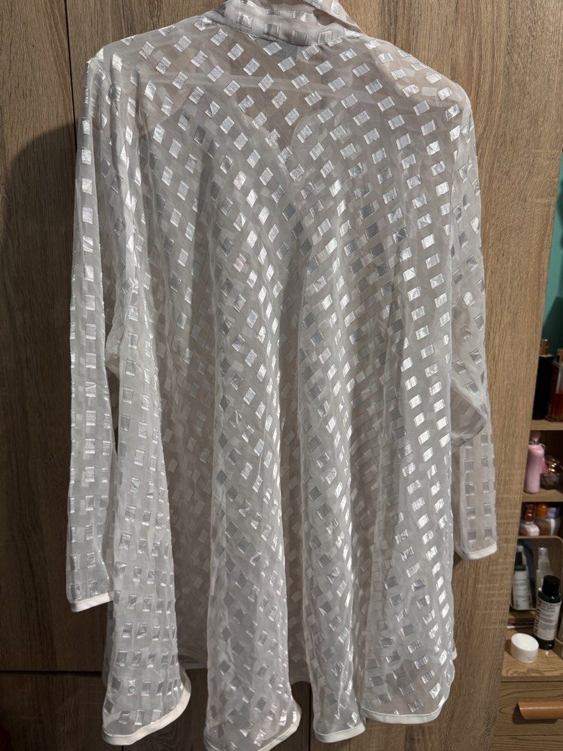 White, long-sleeved, button-down blouse with a distinctive sheer, textured design (Category: Longsleeves) located in Manila. Submitted by chskaiode (Listing ID 1444491870, Image 3). Description: White, long-sleeved, button-down blouse with a distinctive sheer, textured design See through Size: Large- semi XL No issues Complete buttons 📍Mandaluyong.