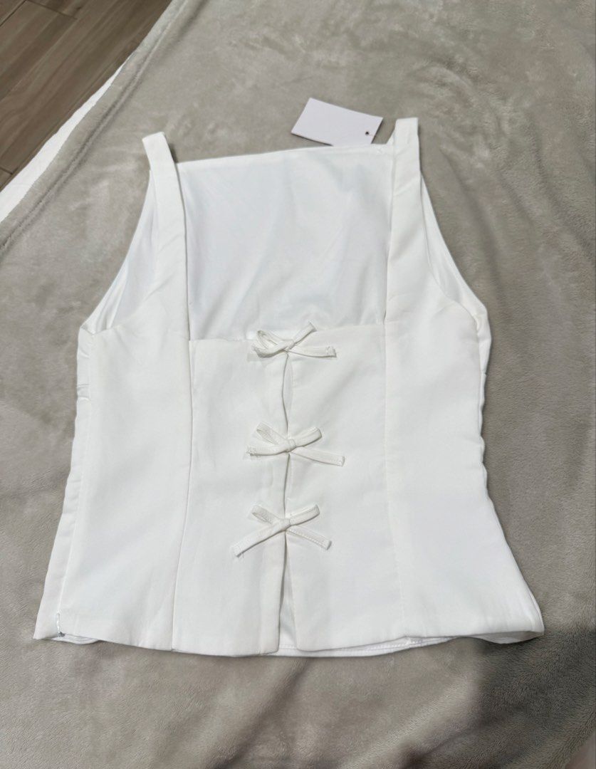 White Square Neck Tank Top (Category: Sleeveless) located in San Juan City. Submitted by eunicezcloset (Listing ID 1444450153, Image 2). Description: - White tank top - Square neckline - Three small bow details on the back - rfs: doesnt fit.